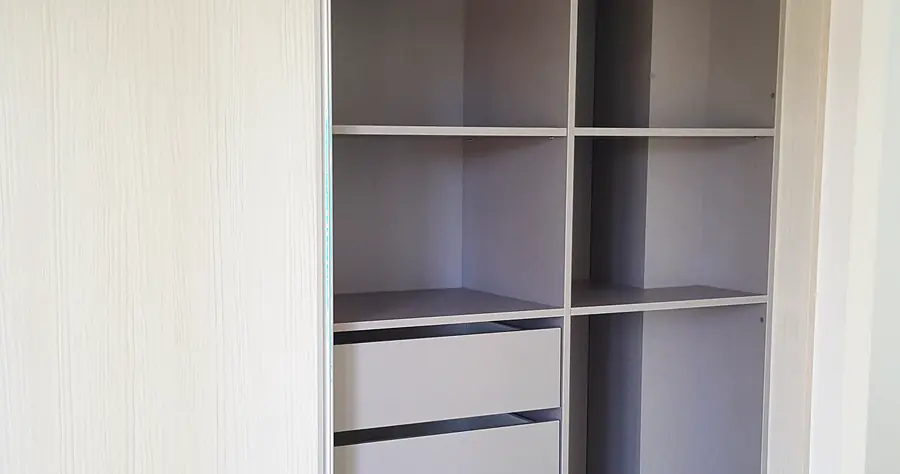 Intérieur d'un dressing sur mesure : étagères modulables et tiroirs à l'anglaise