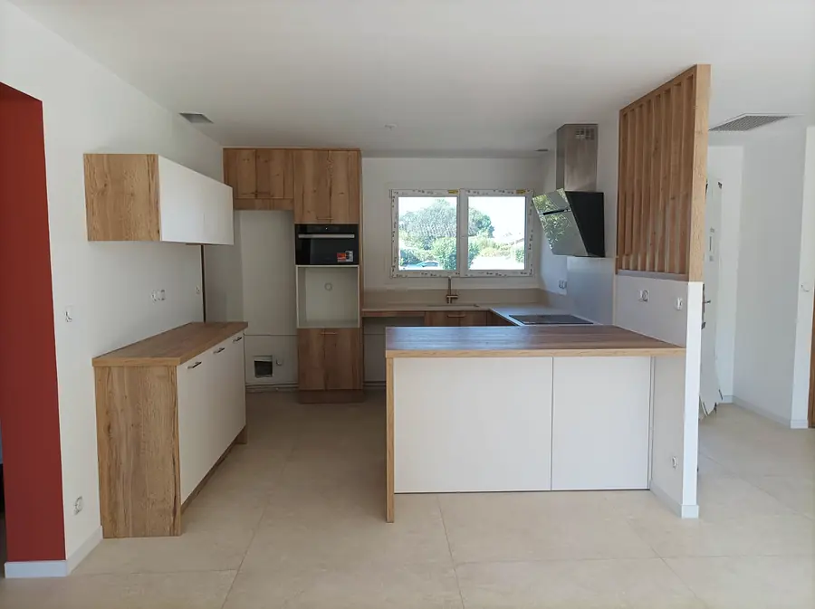 Cuisine sur mesure blanche et bois avec îlot central, plan de travail bois et hotte décorative
