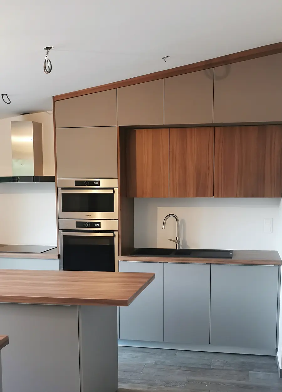 Cuisine sur mesure blanche et bois avec plan de travail foncé et grande ouverture vitrée