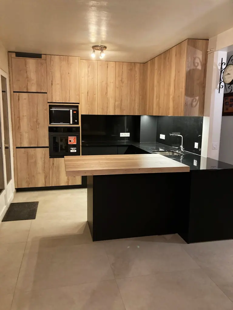 Cuisine sur mesure en bois avec îlot et plan de travail en céramique noire, crédence assortie